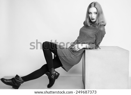 Fashion portrait of young beautiful female model with perfect make up in casual dress and boots.