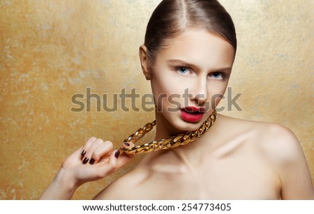 Fashion Beauty Girl Portrait Isolated on golden Background. Glamour Makeup. Gold Jewelry. Hairstyle.