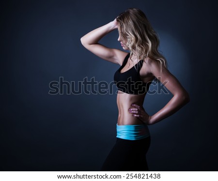 Sport blond woman with wavy hair showing her well trained body and strong abs.