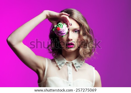 Glamour woman with cake and glamour make up over bright pink background. Fashion photo.