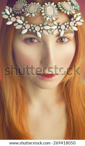 tender portrait of beautiful red haired (ginger) woman with jewelry in her hairs.