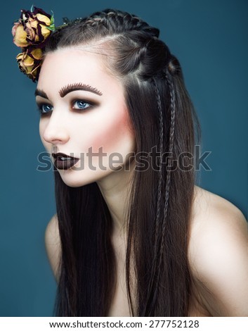 art portrait of brunette woman with roses in hairs. Creative make up and wide eyebrows.