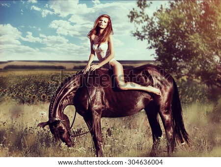Beautiful young lady wearing in sexy lingerie riding a horse at sunny summer day. Vintage and toned photo.