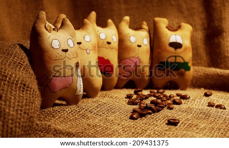 Rag doll handcrafted coffee cats on the background with coffee beans. Cute and funny faces.