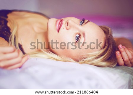 Close up portrait. Beautiful young woman waking up on the bad, morning light. Perfect clean skin and nature make-up