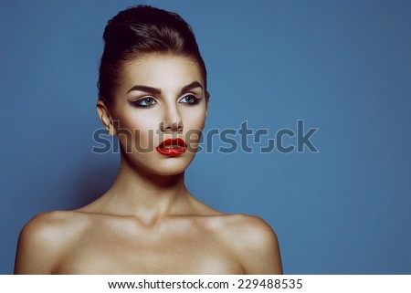 High fashion look. Portrait of a fashionable model with sexy red lips, beautiful naked shoulders and perfect skin. Close up. Studio shot