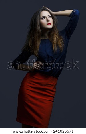 High fashion look. Portrait of a fashionable model with sexy red lips, beautiful red skirt and blue shirt. Close up. Studio shot