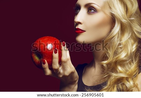 Beautiful Sexy Woman face closeup, makeup with Red Lips, Nails and red apple. Beauty blond Girl. Make up, Hairdo and Manicure. the concept of the first woman on earth (Eve).  Sexy Red Color Lips.
