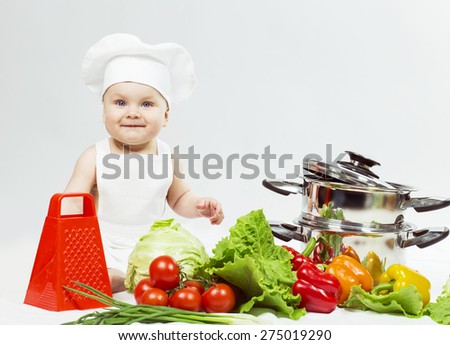 Little Chef boy preparing healthy food and looking and smiling in camera over white background. the concept of vegetarianism