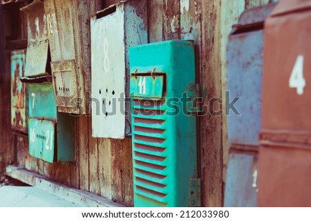 Old memory mailboxes concept. Multicolored old shabby mailboxes with numbers of people\'s memories houses over wooden scuffed background. Outdoor shot. Copy-space.