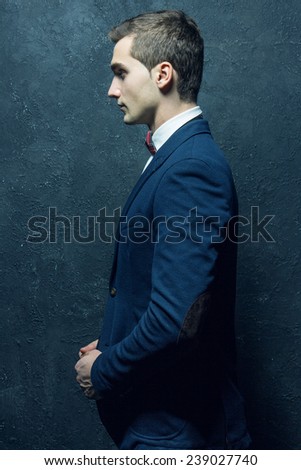 English gentleman male beauty concept. Portrait of fashionable young man in blue casual suit with stylish haircut posing over blue background. Perfect hair & skin. Close up. Studio shot