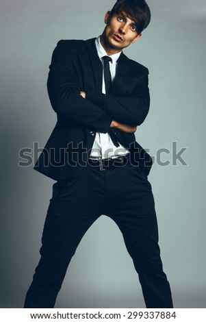 Agent 007 concept. Handsome young man with short hair wearing classic  black&white suit and tie posing over gray background. Classic style. Studio  shot - Stock Image - Everypixel