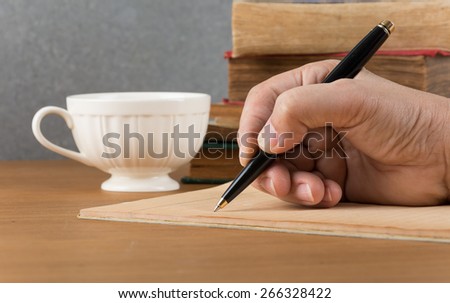 Hand writing a notebook on table