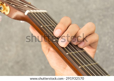 hand playing on acoustic guitar - soft focus with vintage filter