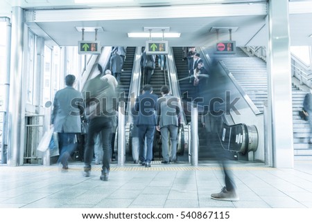 People rush on a escalator motion blurred - blue white balance processing style