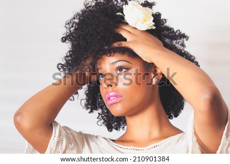 Beautiful young woman with afro with white flower in hair