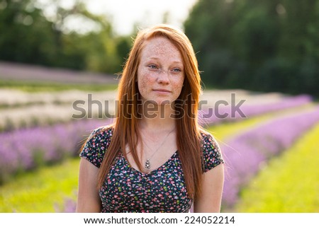 Beautiful young woman with red hair in lavender field