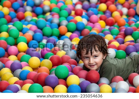 Cute little boy with brown hair playing in ball park