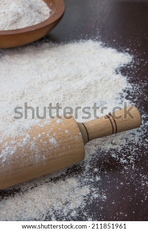 Rolling pin and flour  on an old wooden board