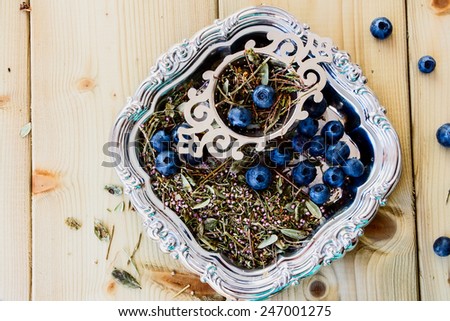 Top view of bio herbal tea and fresh blueberries on wooden background.