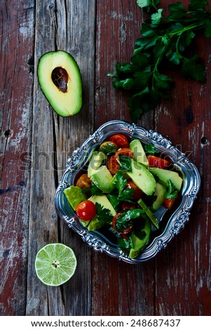Avocado salad in vintage metal plate - healthy food, diet or cooking concept. Top view.