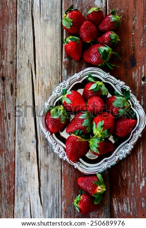 Top view of ripe sweet strawberries on vintage metal plate. Food frame background.
