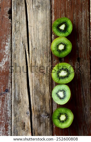 Top view of Fresh kiwi fruits on rustic wooden board. Wood background.