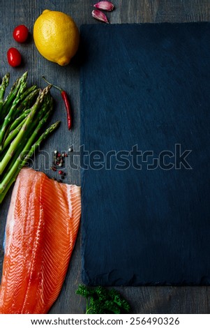 Salmon fillet with asparagus and aromatic herbs, spices and vegetables - healthy food, diet or cooking concept. Top view.