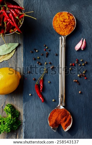 Bright spices over wooden and slate background. Cooking or spicy food concept. Top view.