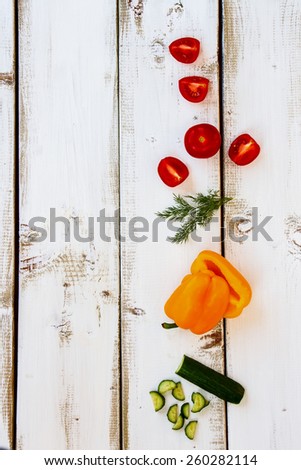 Ingredients of Fresh vegetable salad on white wood board. Healthy food, diet or cooking concept. Top view.