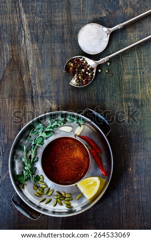 Various herbs and spices selection in vintage spoon on dark wooden board. Food and cuisine ingredients. Top view.