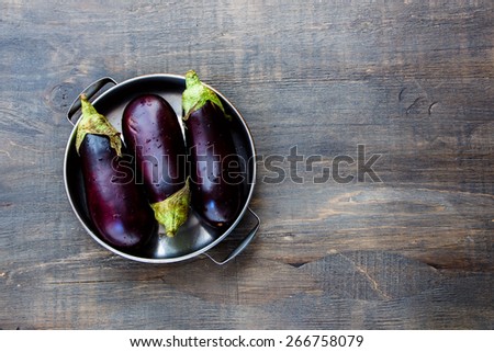 Fresh eggplants on dark wooden background.. Vegetarian food, health or cooking concept.