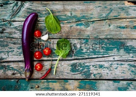 Fresh eggplants and herbs on rustic Wooden Background. Vegetarian food, health or cooking concept. Top view.