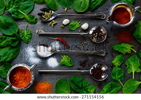 Food Elements - Herbs and spices selection, vintage metal spoons and old dark wood - cooking, healthy eating. Top view.