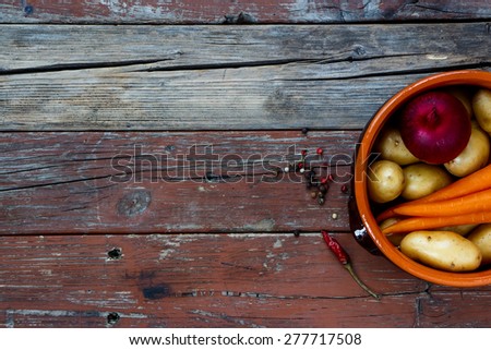Top view of Organic vegetables in rustic clay pot. Food background with space for text. Healthy food from garden.