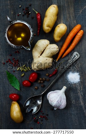 Bio vegetables with herbs and spices on dark background. Vegetarian food, health or cooking concept. Top view.