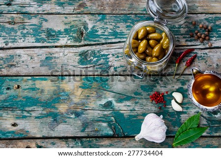 Top view of Olives in jar and Olive Oil on rustic wooden table - italian food concept. Background with space for text.