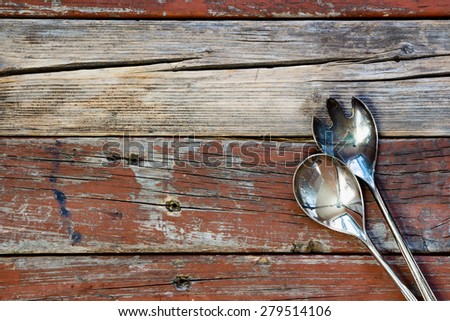 Top view of vintage metal serving spoons on rustic wooden background. Food or cooking concept.