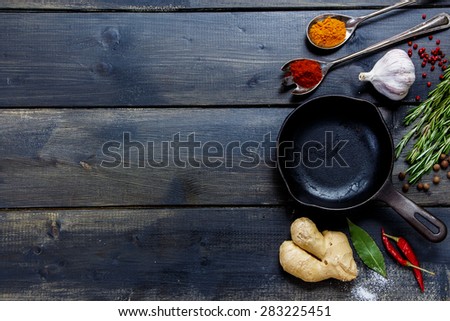 Old cast iron skillet and ingredients on rustic wooden background. Vegetarian food, health or cooking concept.