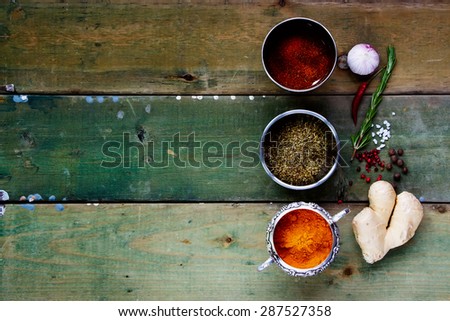 Spices on rustic wood. Herbs and spices selection - old metal cups and wooden background. Cooking, food or health concept. Space for text