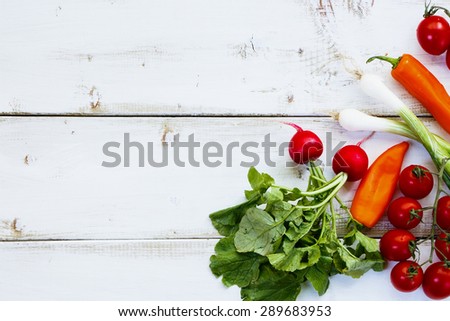 Ingredients of Fresh vegetable salad on white wooden background. Healthy or vegetarian eating concept.