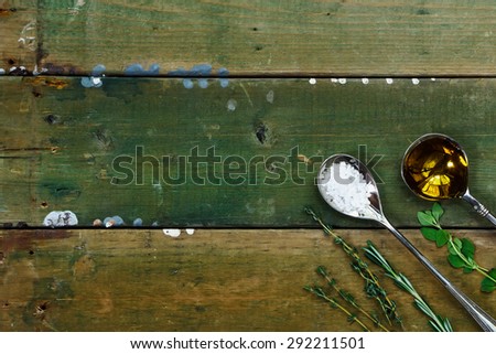 Herbs, sea salt and olive oil on rustic wooden table. Food background with space for text. Health or cooking concept.