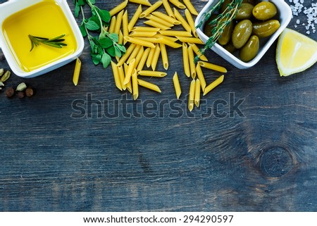 Raw pasta with olive oil, herbs and spices on dark wooden background with space for text.Vegetarian food, health or cooking concept.