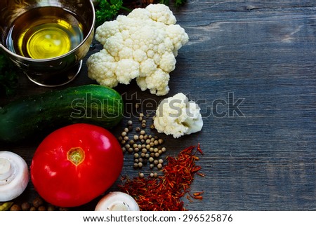 Assortment of ingredients (farm vegetables, olive oil, herbs, spices and mushrooms) on rustic wooden background with space for text. Vegetarian food, health or cooking concept.