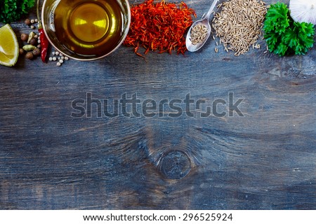 Top view of herbs, spices, olive oil, salt and lemon on dark wooden background with space for text. Food and cuisine ingredients.