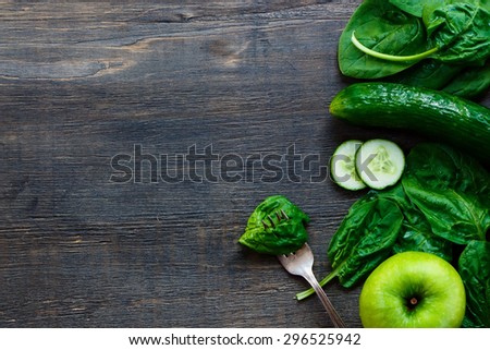 Fresh green vegetables on dark wooden background with space for text - detox, diet or healthy food concept.