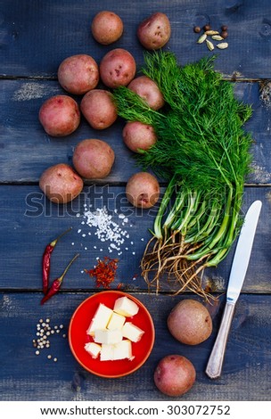 Fresh ingredients (potatoes, dill, butter, spices)l ready for cooking over old wooden background. Fresh organic vegetables. Healthy food from garden. Health, vegetarian food or cooking concept.