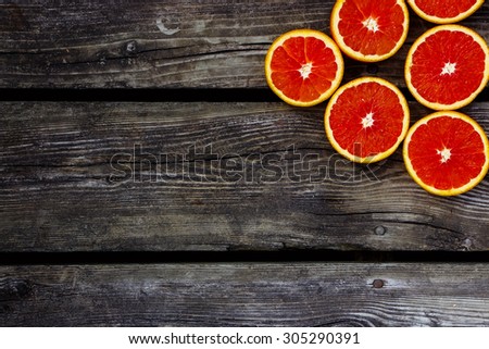 Healthy food. Fresh oranges halves fruits on rustic wooden background with space for text.