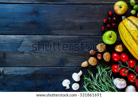Vegetables, fruits, nuts and herbs on dark wood. Healthy food ingredients background with space for text. Health or diet concept. Top view.