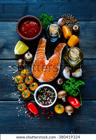 Raw steak of salmon with fresh ingredients for tasty cooking on rustic wooden background, top view, banner. Healthy food concept.
